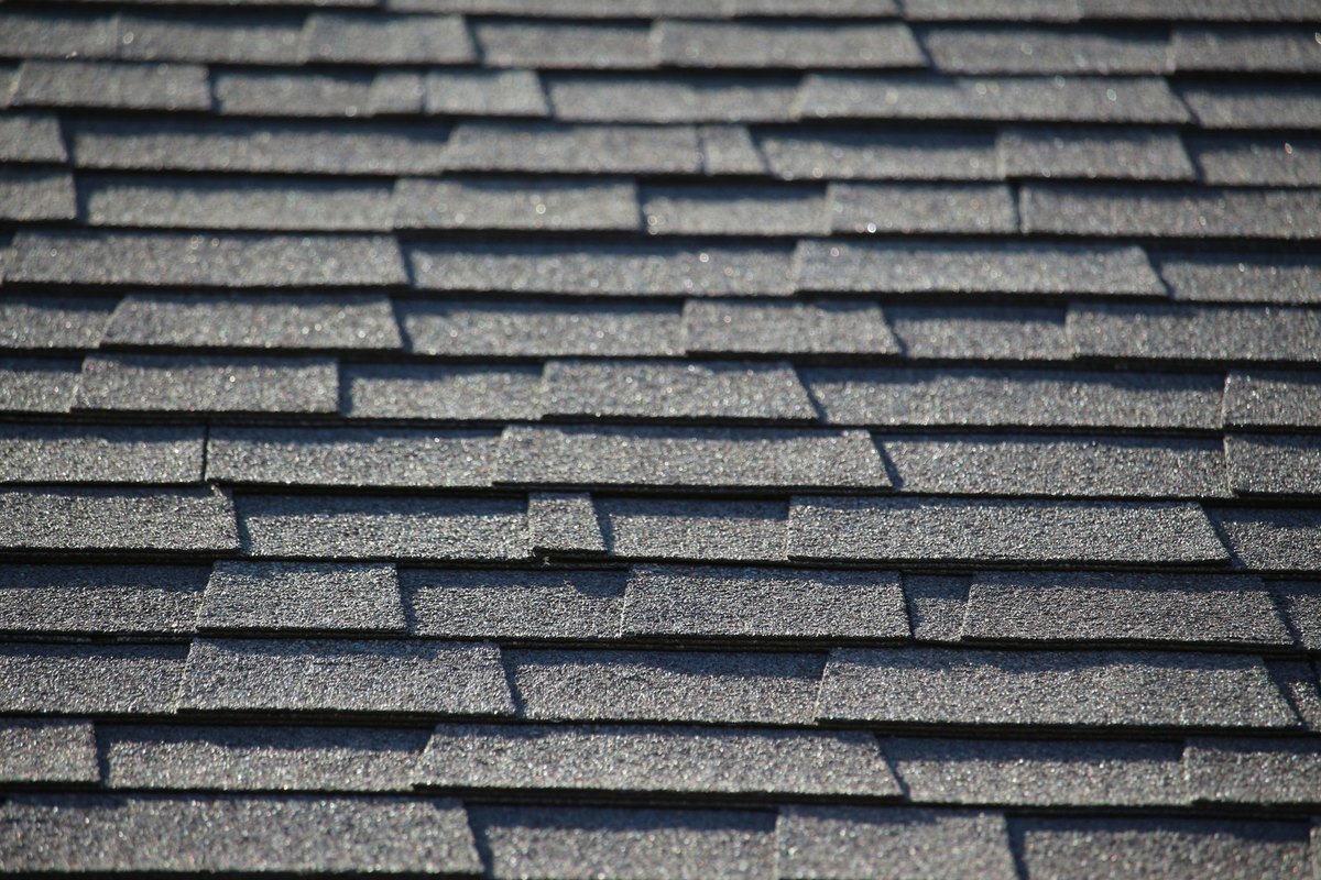 Clean dark gray architectural asphalt shingles in straight overlapping rows
